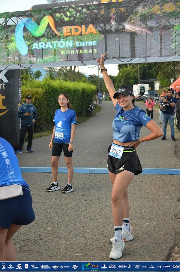 Corredora feliz cruza la meta de la Media Maratón Entre Montañas.