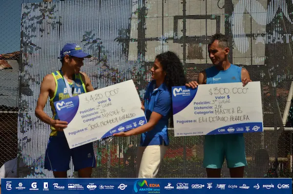 Corredora cruza la meta de la Media Maratón Entre Montañas con los brazos en alto.